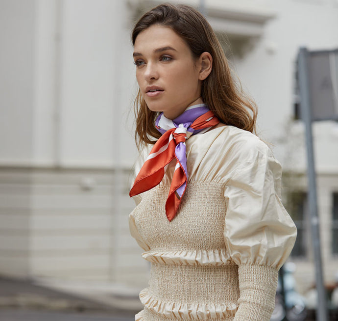 Model walking on street with Sésam modern fleur italian silk twill scarf around neck