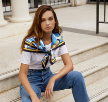 Load image into Gallery viewer, Sésam capri foulard gold and blue silk twill scarf on model sitting on steps